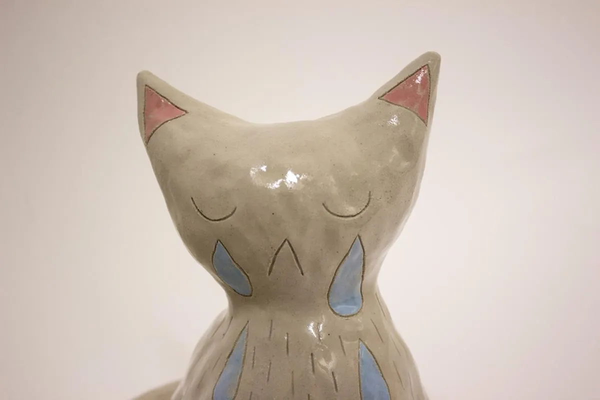 gråtande keramisk katt