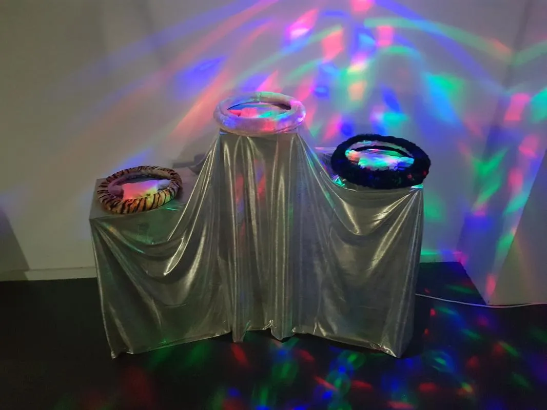 installation med keramiska skulpturer, tyg, discobelysning